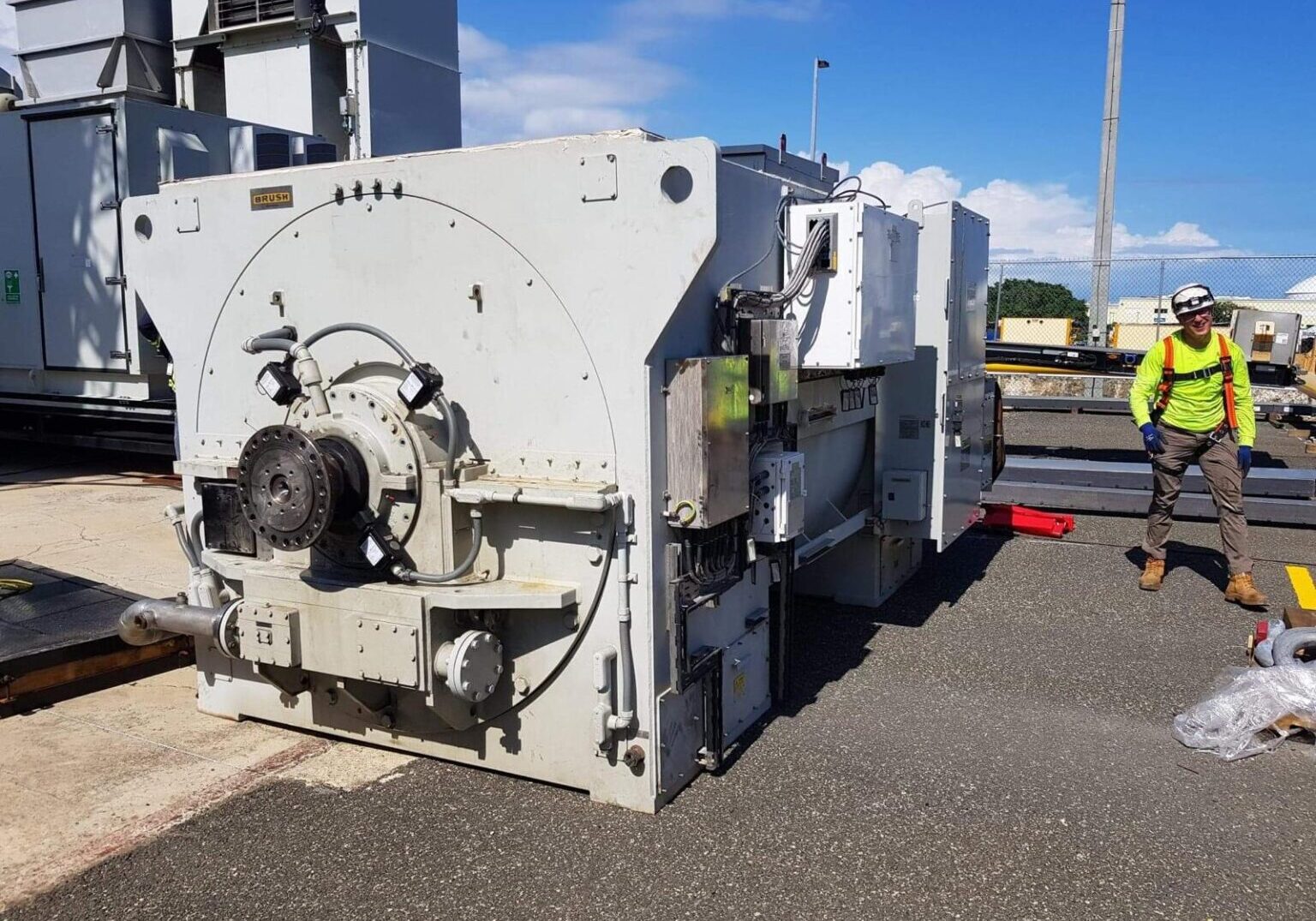 A large white machine sitting on the side of a road.